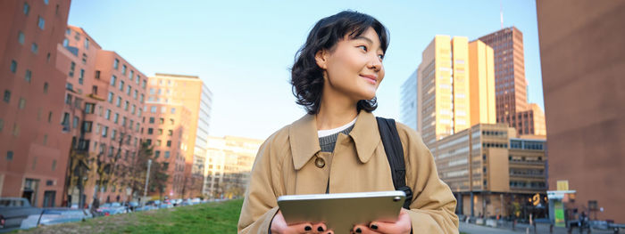 Young woman using mobile phone in city