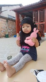 Full length of cute baby girl sitting outdoors