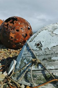 Close-up of abandoned rusty against sky