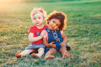 Cute baby girl sitting on field