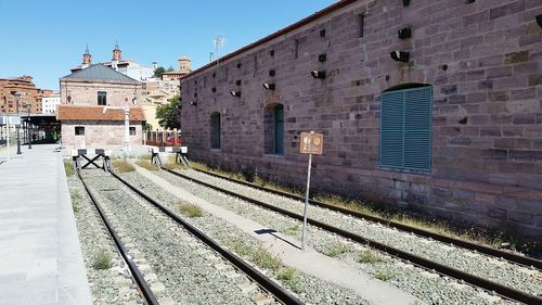 Railroad tracks by buildings against sky