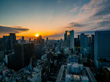 Aerial view of modern buildings against sky during sunset