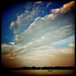 Scenic view of river against cloudy sky