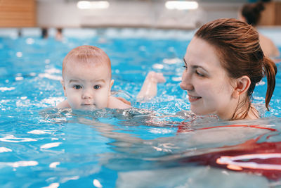 Woman holding baby boy in swimming pool