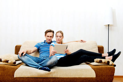 Couple discussing over digital tablet at home