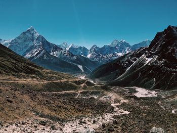 Scenic view of snowcapped mountains against blue sky