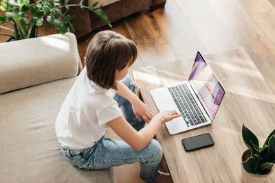 High angle view of woman using laptop while sitting at home