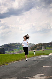 Full length of woman running on road