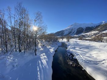 Scenic view of snowcapped mountains against clear blue sky