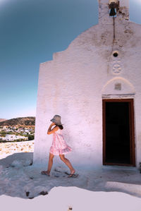Woman standing on sand against clear sky