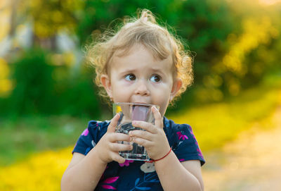 Cute girl looking away while drinking water