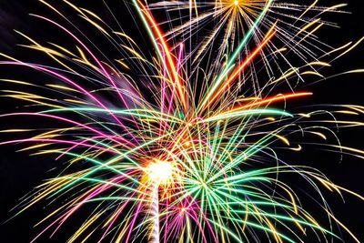 Low angle view of firework display against sky at night