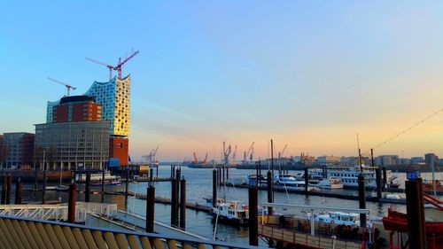 Cranes at harbor during sunset