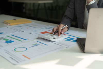 Midsection of business colleagues working on table