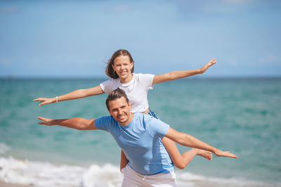 Side view of young woman doing yoga at beach