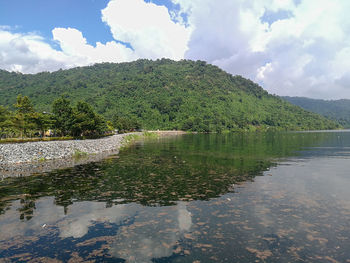 Scenic view of lake by trees against sky