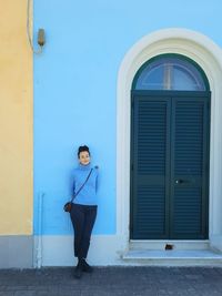 Full length of woman standing against building