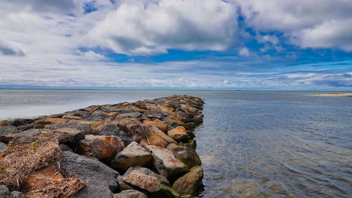 Rocks on sea shore against sky