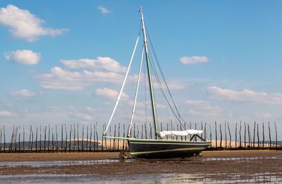 Sailboats moored in sea against sky