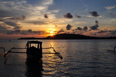 Silhouette boat in sea against sky during sunset