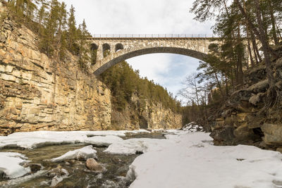 Bridge over river against sky during winter