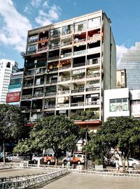 Buildings by road against sky in city