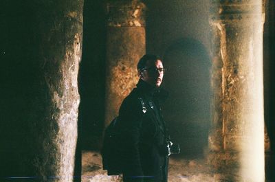 Side view of man standing in old room