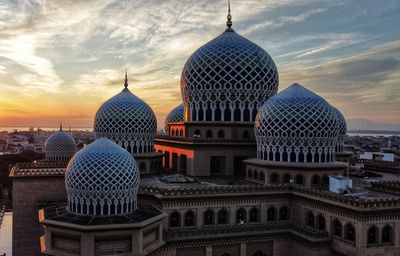 Buildings in city against sky during sunset