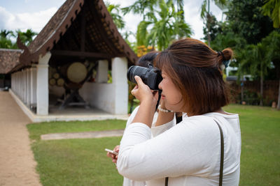 Woman photographing while holding camera