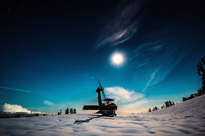 Helicopter on snowy hill against blue sky at dusk