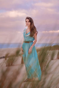 Full length of a smiling young woman standing on beach