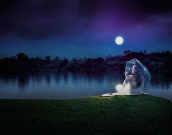 Woman by lake against sky