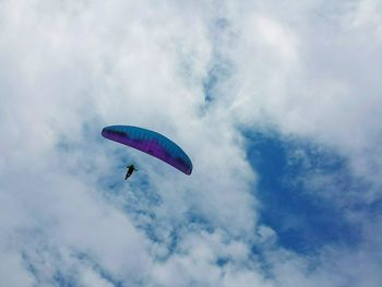 Low angle view of parachute against cloudy sky