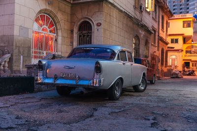 Vintage car on street by buildings in city