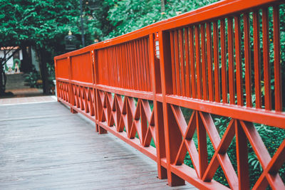 Red metallic structure on footpath by trees