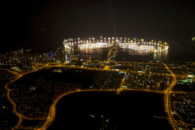 Illuminated cityscape against sky at night