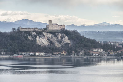 Scenic view of lake by buildings against sky