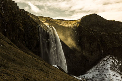 Scenic view of waterfall against sky