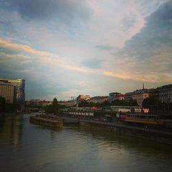 River in city against cloudy sky