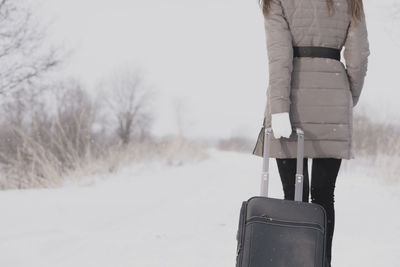 Rear view of person standing on snow covered land