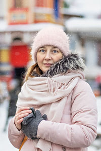 Portrait of a young woman in warm winter clothes outdoors while traveling. winter time, snow.