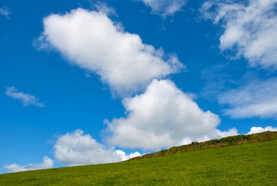 Low angle view of hill against blue sky