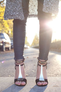 Low section of woman standing on road