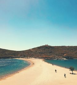 Scenic view of beach by mountains against sky