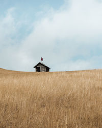 Lifeguard hut on field against sky