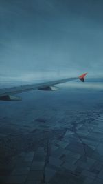 Airplane flying over sea against sky