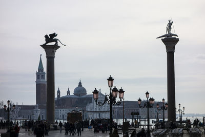 People at piazza san marco with san giorgio maggiore against sky