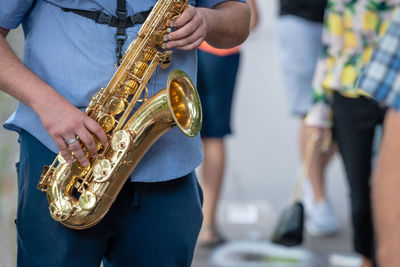 Midsection of man playing saxophone 