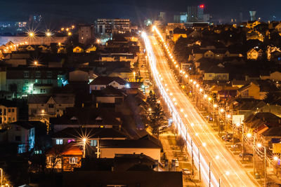 High angle view of illuminated street amidst buildings at night