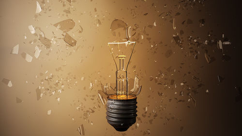 Close-up of broken light bulb against wall